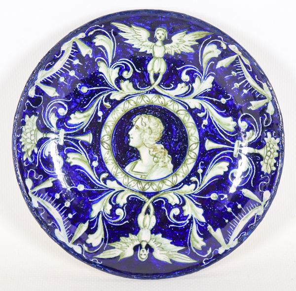 Piattino in maiolica di Pesaro blu marcato Molaroni (1908-1920), interamente decorato a motivi di cariatidi e volute, al centro medaglione con "Ritratto di giovane dama"