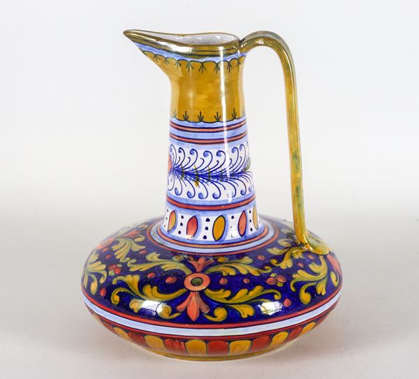 Brocca con manico in maiolica lustrata Gualdo Tadino - Rubboli, interamente decorata su fondo blu e bianco a volute floreali e foglie d'acanto. Anni '30 