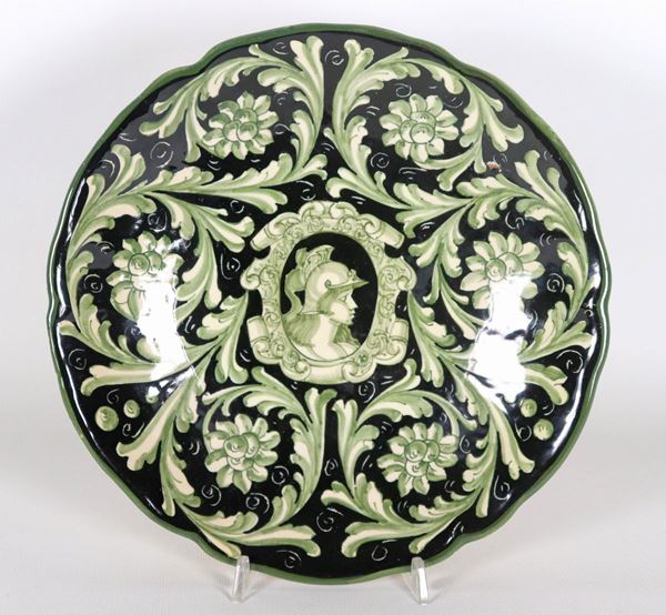 Majolica plate with decorations on a blue background with scrolls of leaves and medallion in the center with "Soldier's face". Marked F.A.M.A. (Artistic Majolica Artisan Factory) Ascoli Piceno - 1930s-40s