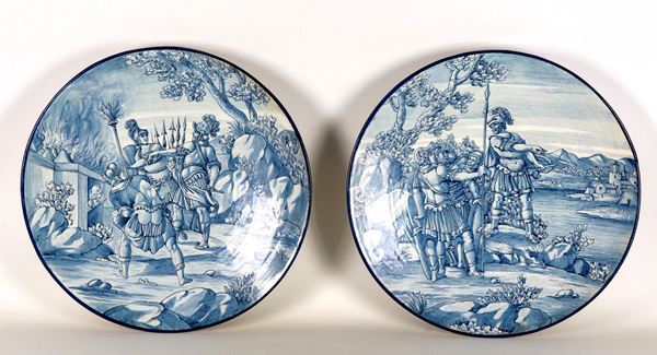 Pair of large Florentine majolica parade plates, marked E.C. (Ernesto Conti Sesto Fiorentino), entirely decorated in blue with scenes of Roman soldiers before the battle