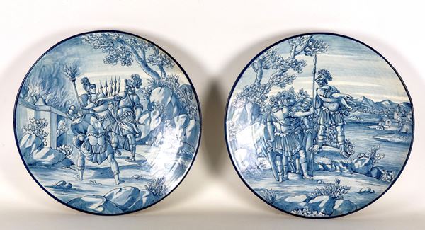 Coppia di grandi piatti da parata in maiolica fiorentina, marcati E.C. (Ernesto Conti Sesto Fiorentino), interamente decorati in blu con scene di soldati romani prima della battaglia