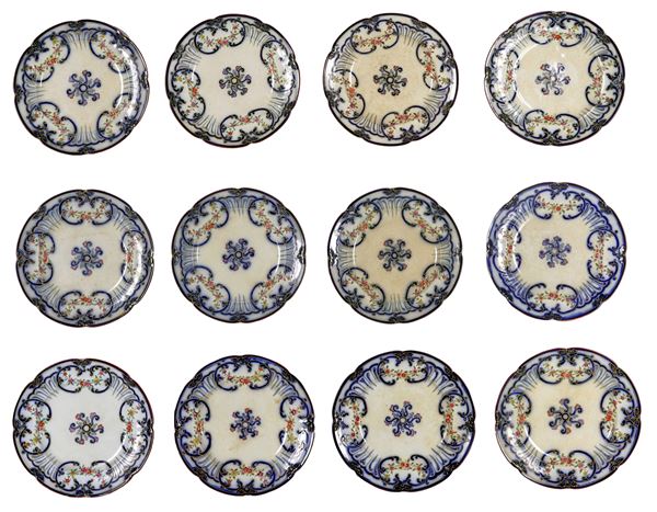 Antique lot of twelve English earthenware wall plates, with enamel decorations with motifs of scrolls and floral garlands, Victorian era