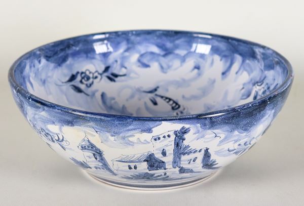 Ciotola tonda in maiolica lustrata di Albisola, interamente decorata in blu a motivo di paesaggio con castello. Sul fondo presenta rottura