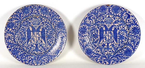 Coppia di antichi piatti da muro in maiolica con decorazioni in blu, al centro stemma gentilizio