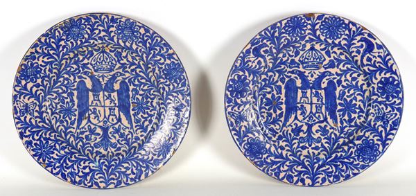 Pair of antique majolica wall plates with blue decorations, noble coat of arms in the centre