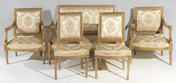 Salotto francese di linea Luigi XVI in legno dorato e intagliato a motivi neoclassici, copertura in raso avana damascato: divano, due poltrone e due sedie (5 pz)