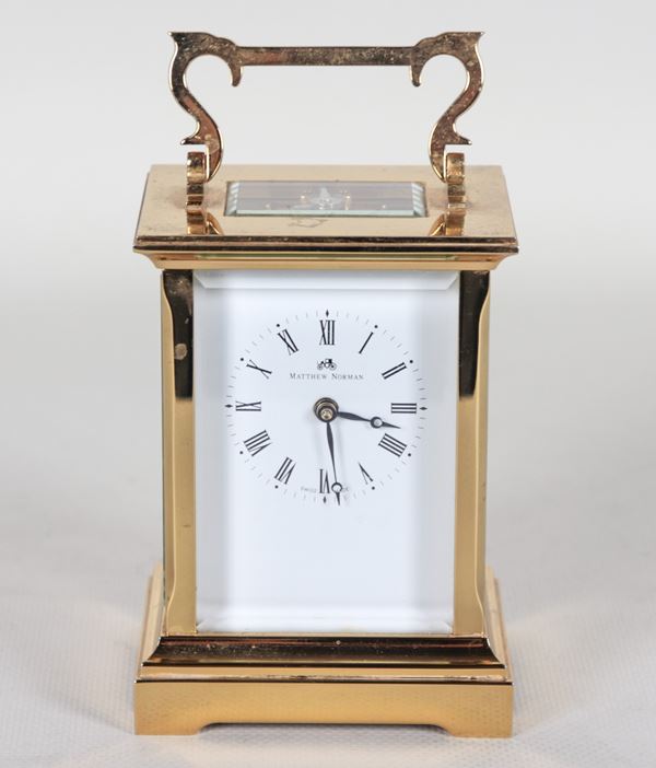 Gilt brass carriage clock with white enamel dial with Roman numerals. Signed Matthew Norman