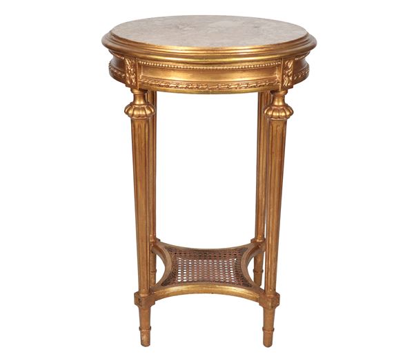 Piccolo tavolo francese da centro di linea Luigi XVI, a forma tonda in legno dorato e intagliato, con quattro gambe a cono scannellato riunite da pianetto centinato con canneté e piano in marmo