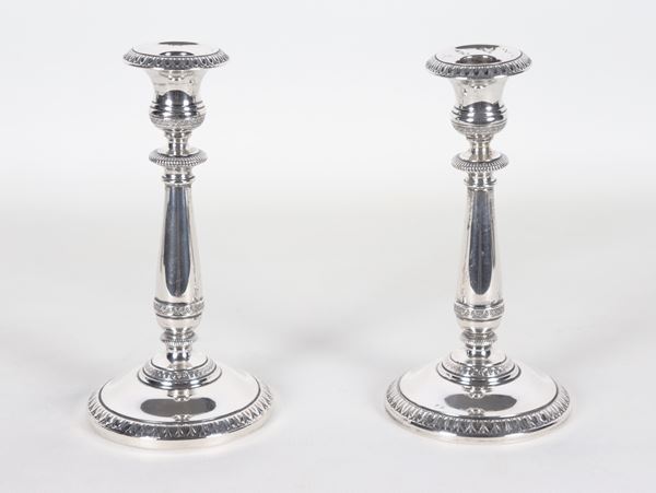 Coppia di candelieri in argento cesellato e sbalzato a motivi Impero, gr. 230