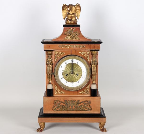 Ancient Empire period table clock in the shape of a small temple, in cherry wood and ebonized wood profiles, friezes and trimmings in gilded and chiseled bronze and dial in bronze and white enamel
