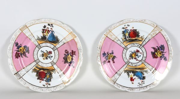 Coppia di piatti da muro in porcellana Vienna, con decorazioni variopinte a motivi di scene galanti e mazzetti di fiori