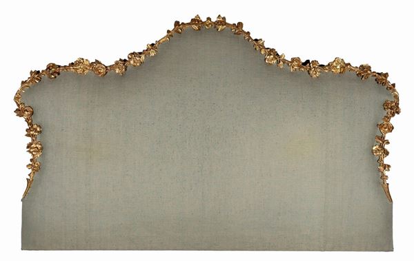 Headboard in gilded wood and carved with floral garland motifs, gray fabric cover