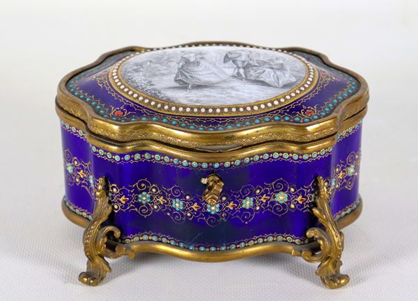 Antica scatola francese a forma ovale centinata in smalto blu cobalto con ghirlande floreali, sul coperchio medaglione dipinto con “Scena galante”, guarnizioni e piedini in bronzo dorato e cesellato. Rottura sulla parte frontale