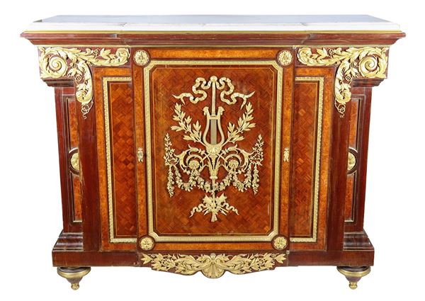 Antique French Napoleon III servant (1852-1870) in bois de rose, mahogany, purple ebony and thuja, with marqueterie inlays and friezes and trimmings in gilded and chiselled bronze with Louis XVI motifs of floral interlacing, acanthus leaves, bow with lyre and rosettes. A central door and top in white statuary marble