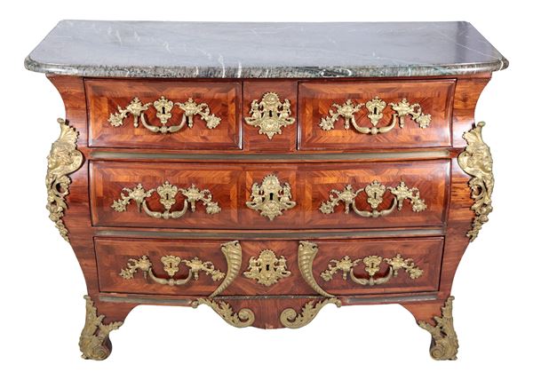 Antica commode francese Napoleone III (1852-1870) in ebano viola e bois de rose, a forma bombata con guarnizioni e fregi in bronzo dorato e cesellato di teste muliebri, motivi floreali, fiocchi e cornucopie, quattro tiretti e piano in marmo