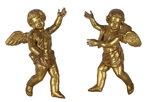 Pair of small "Winged Putti" sculptures in gilded and carved wood, slight defects