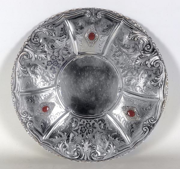 Antique round silver centrepiece, chiselled and embossed in relief with scrolls of acanthus leaves and bunches of flowers with applications of agate-coloured semi-precious stones, supported by three lion feet, gr. 640
