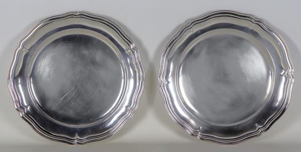 Coppia di grandi piatti tondi da portata in argento con bordi centinati e sbalzati, gr. 2100