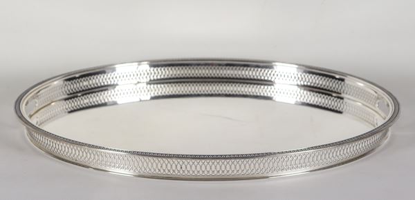 Grande vassoio ovale in argento, con bordo a ringhierina traforata e due manici. Il fondo interno presenta qualche rigatura, gr. 1820