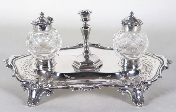 Antique inkwell from the Queen Victoria era, in chiselled and embossed silver with central candle holder, two crystal bottles and four curved feet. Stamps London 1857 gr. 385
