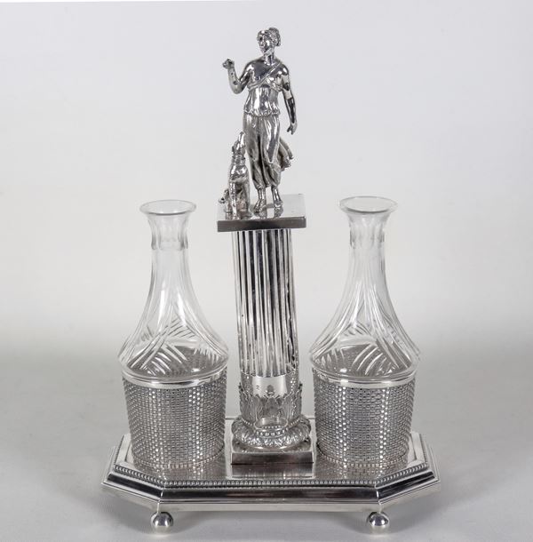 Ancient chiselled and embossed silver cruet with neoclassical motifs with sculpture of Venus and dog, two crystal cruets missing their caps, one with a slight chip on the edge of the neck. Stamps Italy Early 19th Century, gr. 840