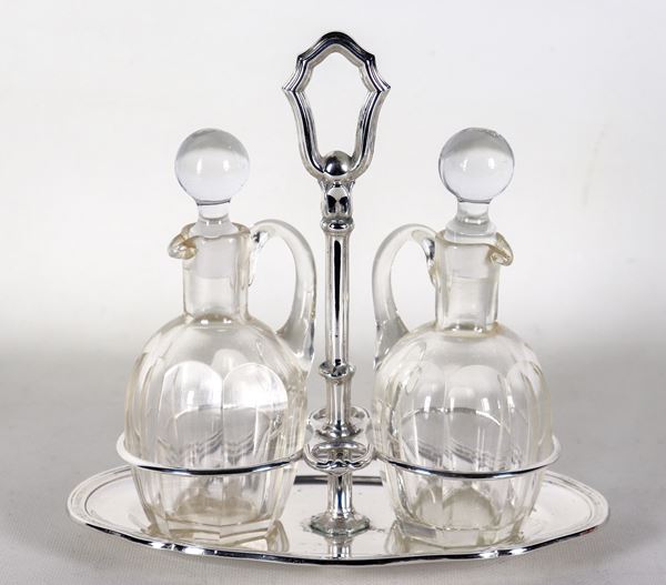 Oval silver cruet with curved and embossed edge, two crystal cruets. One ampoule has a broken neck, gr. 270