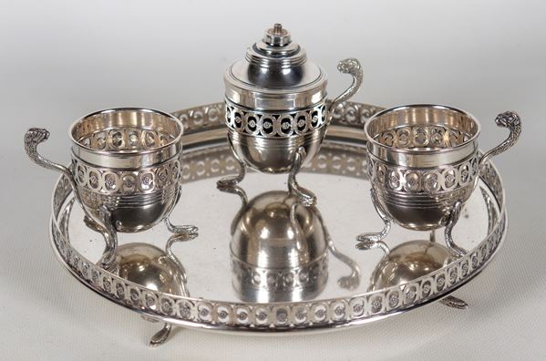 Lot in chiselled and embossed silver with Empire motifs of a small round tray with perforated edge, a wick and two cups (4 pcs), gr. 875