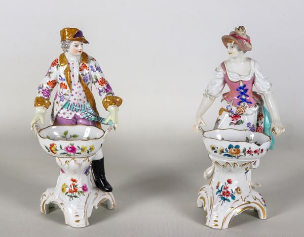 Coppia di antiche saliere in porcellana policroma e smaltata Vecchia Berlino, con sculture raffiguranti "Contadino e contadina con cesti", difetti e mancanze