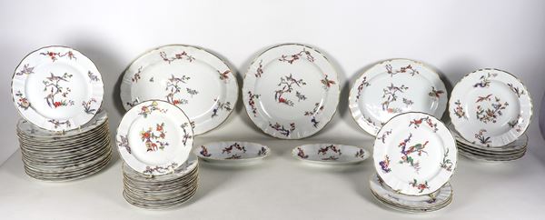 Servizio di piatti in porcellana bianca di Limoges-L. BERNARDAUD & C., con decorazioni dipinte a rilievo a motivi di cineserie e bordi in oro zecchino (45 pz). Due piatti presentano lieve sbeccatura al bordo