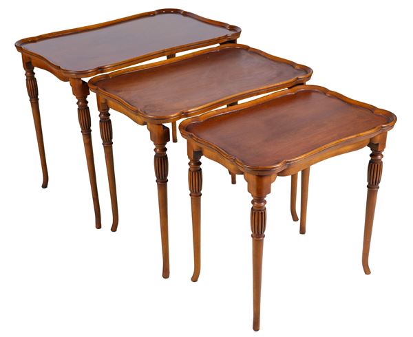 Nest of three mahogany tables, with curved tops and columned legs