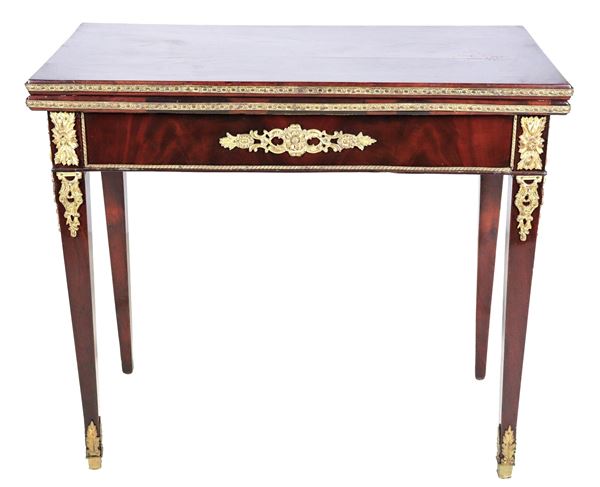 French center table in mahogany and mahogany feather, with friezes and trimmings in gilded and chiseled bronze with Empire motifs, folding top with central green cloth inside and four inverted truncated pyramid legs