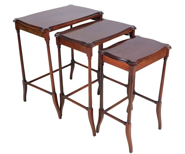 Nest of three walnut tables with carved legs and raised edges