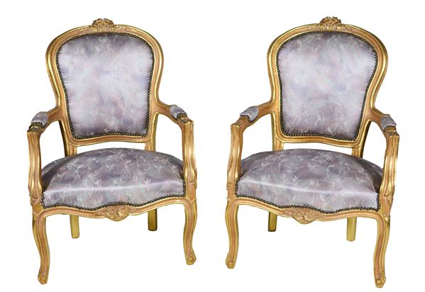 Pair of French armchairs from the Louis XV line, in gilded wood and carved with floral motifs, armrests and curved legs