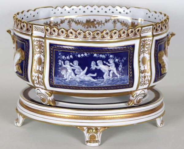French porcelain jar with neoclassical decorations in relief with "Allegory of putti" motifs and pure gold trimmings, supported by an oval base with four curved feet