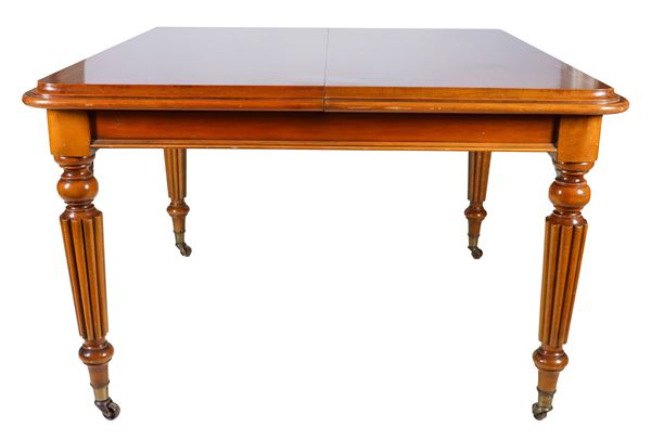 Antique Victorian era extendable dining table in walnut, with threaded inlaid top, four pod legs and opening with crank mechanism. A 40 cm extension
