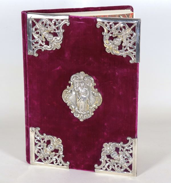 Libro commemorativo per firme, con rivestimento in velluto rosso porpora e applicazioni di antichi fregi in argento cesellato e sbalzato, con teste di angeli agli angoli e figura di Santa al centro