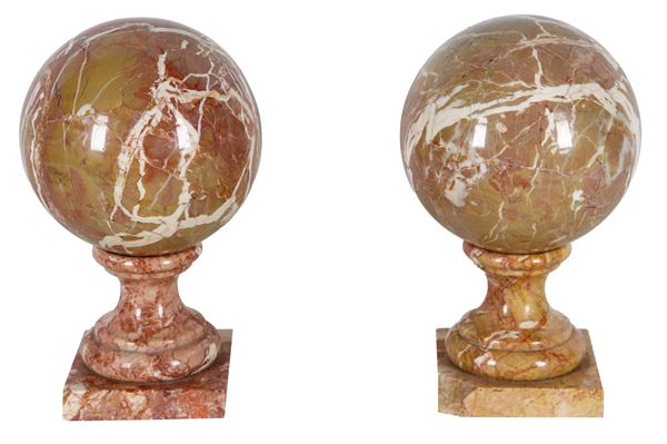 Pair of brecciated and veined marble spheres with bases, missing bases