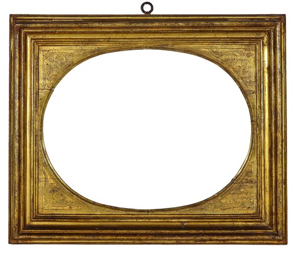 Ancient gilded and carved wooden frame in an oval shape. Nineteenth century