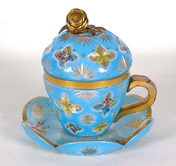 Antique French cup and plate in light blue crystal with colorful decorations of floral and leaf motifs, rose-shaped knob in gilded bronze and highlights in pure gold