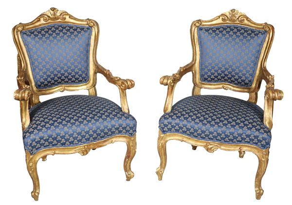 Pair of ancient Roman armchairs from the Louis XV line, in gilded and carved wood with curved armrests and handles, cover in flowered blue fabric