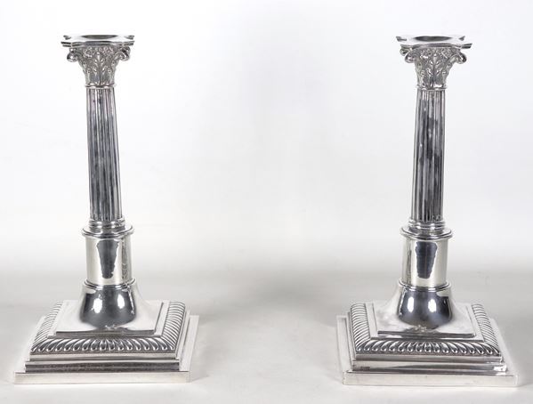 Coppia di antichi candelieri in argento cesellato e sbalzato a forma di colonne corinzie con base quadrangolare, gr. 1740