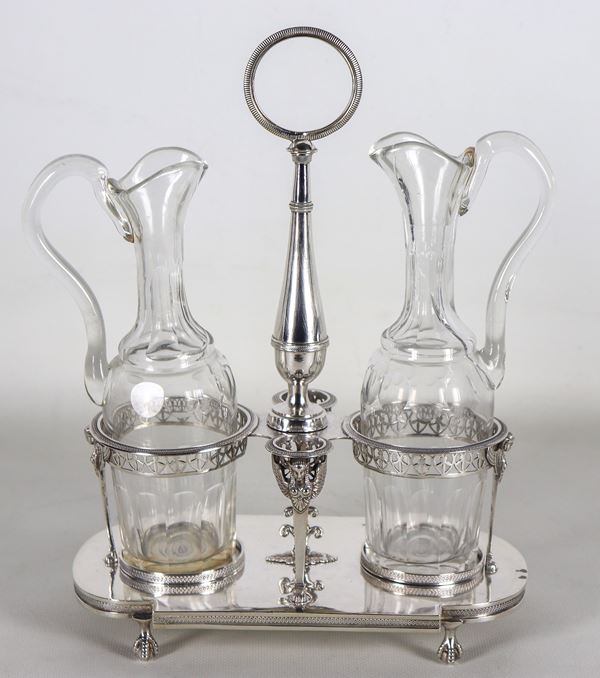 Antica oliera francese Luigi XVI in argento, cesellata e sbalzata con sfingi alate e bordi traforati, sorretta da quattro piedini e con due ampolle in cristallo, gr. 640. Bolli Parigi 1784