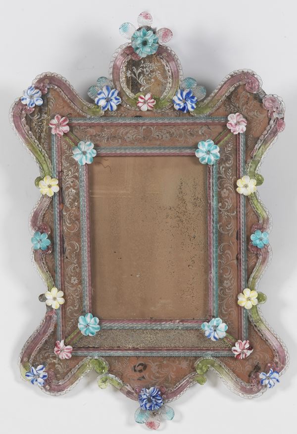 Antica specchiera veneziana in vetro soffiato di Murano, con applicazioni di fiori colorati a rilievo e fondi dei vetri incisi, qualche difetto e mancanze