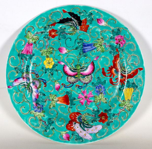 Chinese porcelain wall plate, entirely decorated with polychrome enamels in relief with flower and butterfly motifs