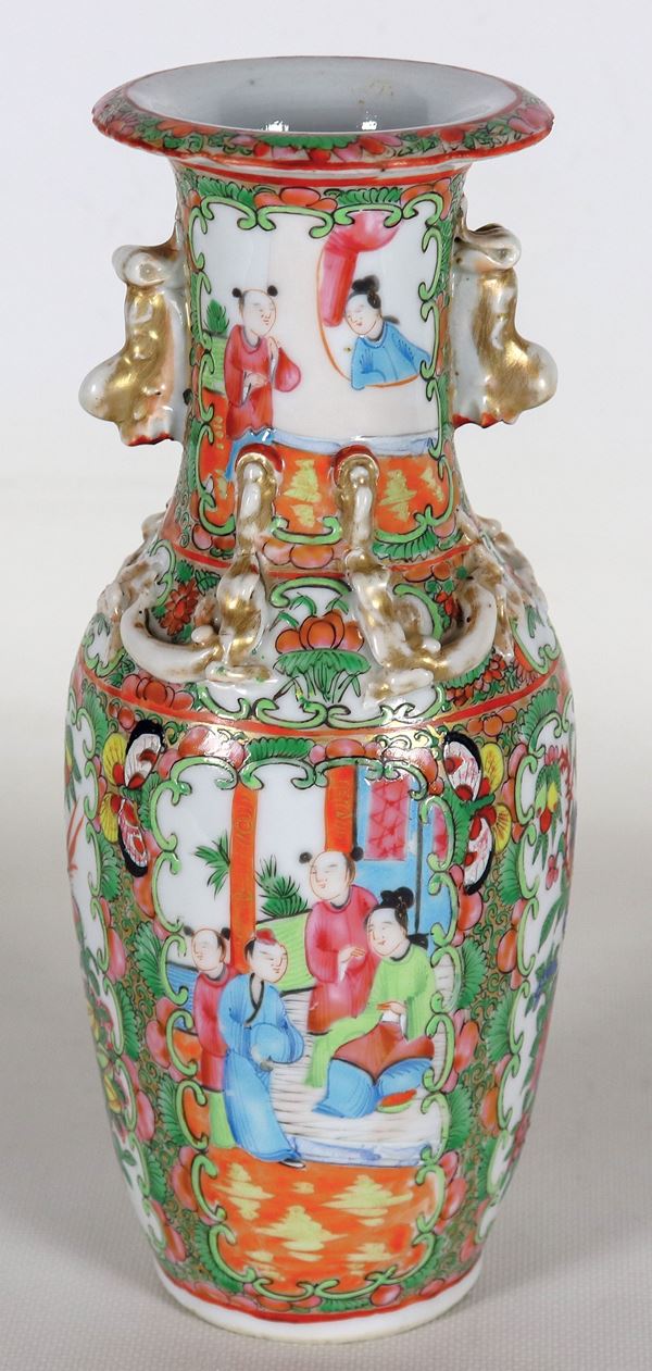 Antique Chinese vase in Canton porcelain, with relief enamel decorations of oriental life scenes, flowers and parrots. Slight defects and slight chipping on the edge of the bottom