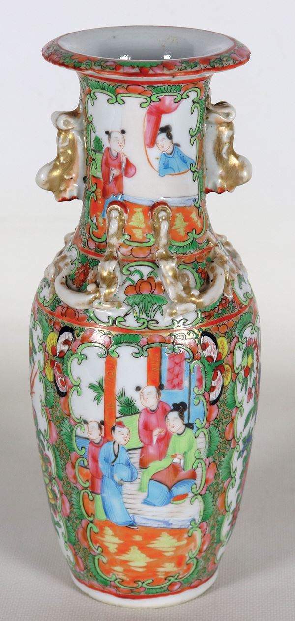 Antico vaso cinese in porcellana Canton, con decorazioni in smalti a rilievo di scene di vita orientale, fiori e pappagalli. Lievi mancanze e lieve sbeccatura al bordo del fondo