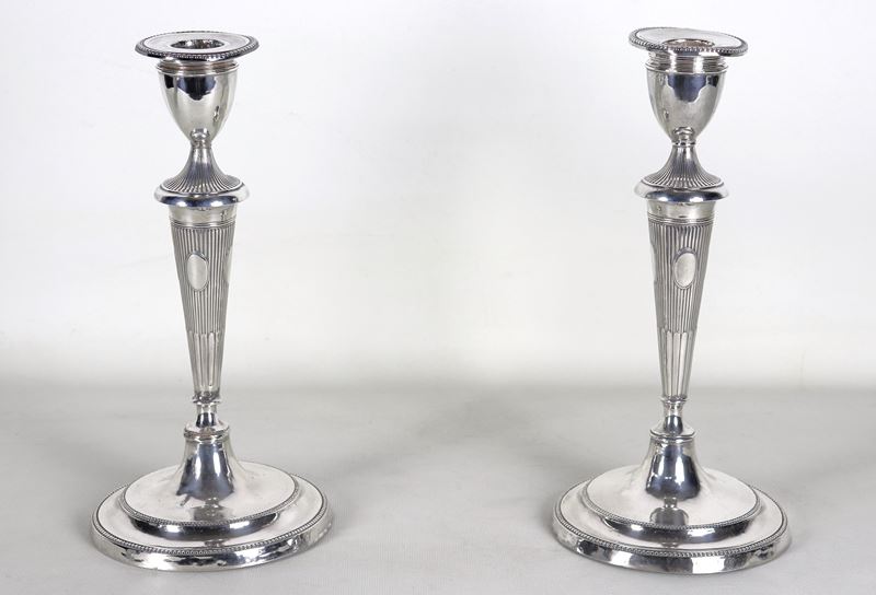 Coppia di antichi candelieri Giorgio III, in argento cesellato e sbalzato a motivi di baccellatur...