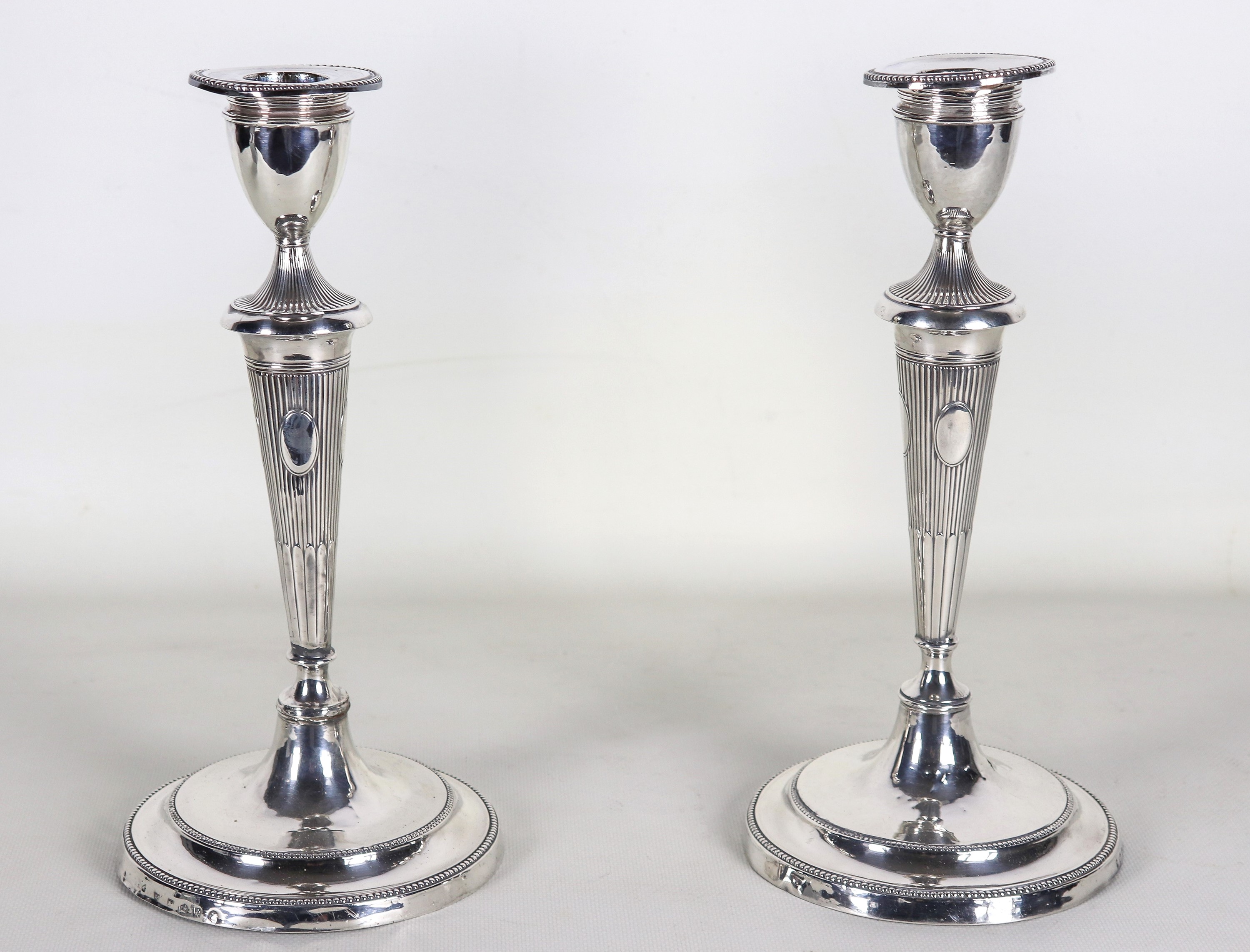 Coppia di antichi candelieri Giorgio III, in argento cesellato e sbalzato a motivi di baccellatur...