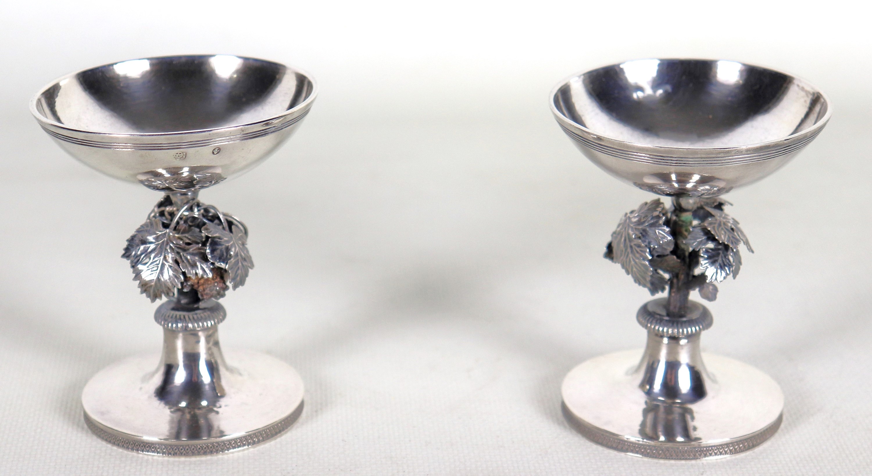 Coppia di antiche piccole saliere in argento, cesellate e sbalzate con tralci d'uva e perlinature...