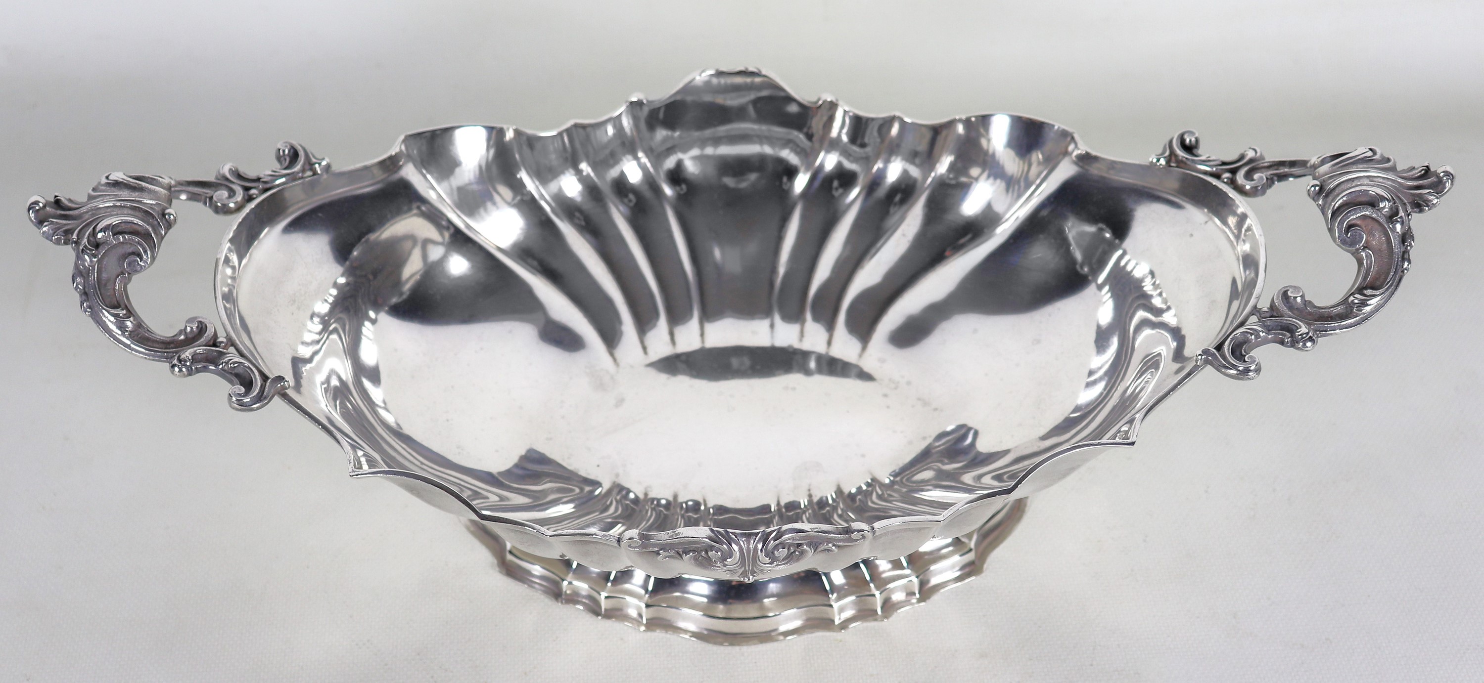 Antico centrotavola in argento con bordo centinato e due manici cesellati e sbalzati, gr. 990